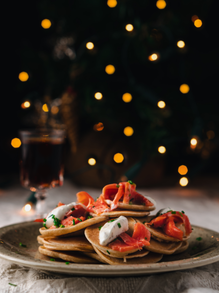 Mini blini topped with smoked salmon, crème fraîche, and dill for Christmas appetizers.