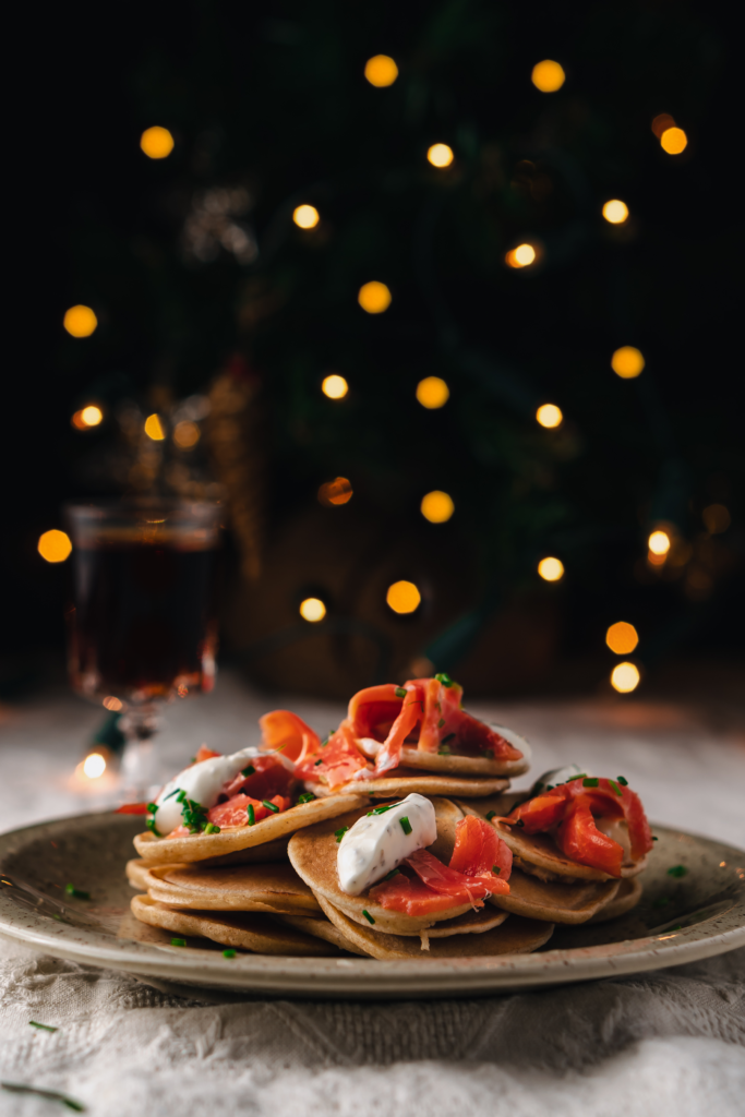 Mini blini topped with smoked salmon, crème fraîche, and dill for Christmas appetizers.