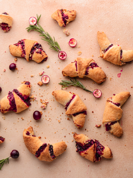 Festive rugelach pastries with sweet cranberry filling and nut topping.